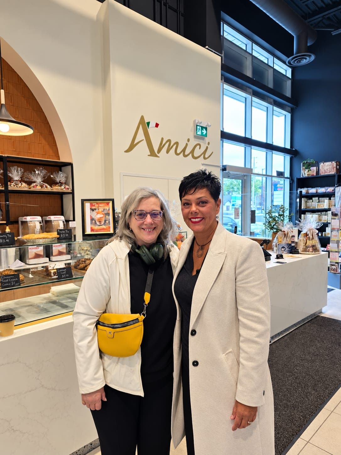 Ivana White with a resident by the counter at Amici Deli & Bakery.