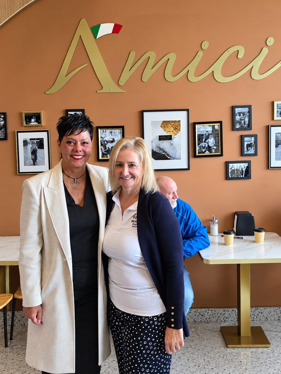 Ivana White with a resident in front of the Amici sign.