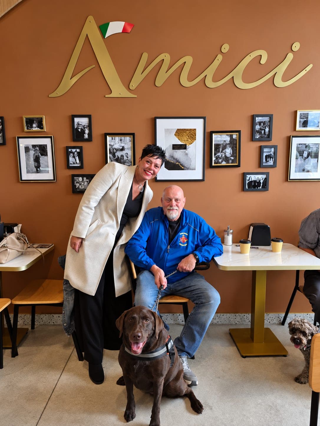 Ivana White beside a seated resident and his dog at Amici.