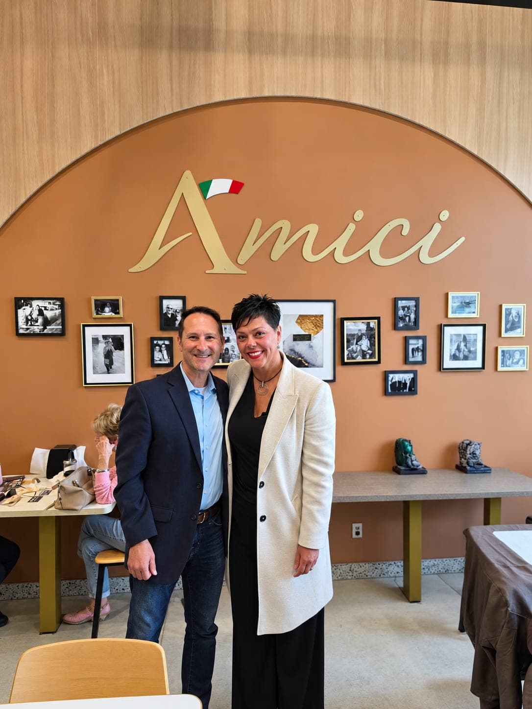 Ivana White with a resident in front of the Amici sign.